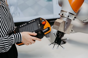 Person steuert einen Roboter.